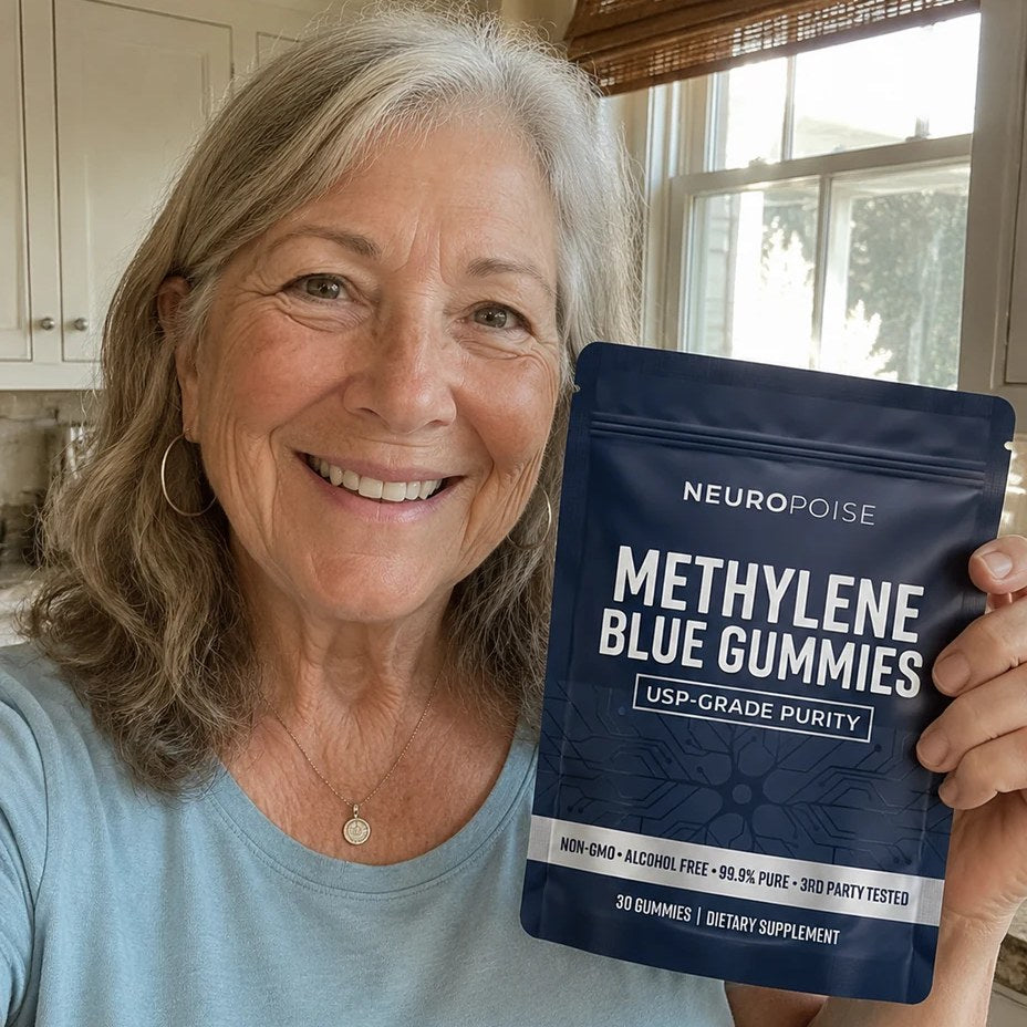 A smiling senior woman holding a pack of Neuropoise Methylene Blue Gummies in her kitchen.