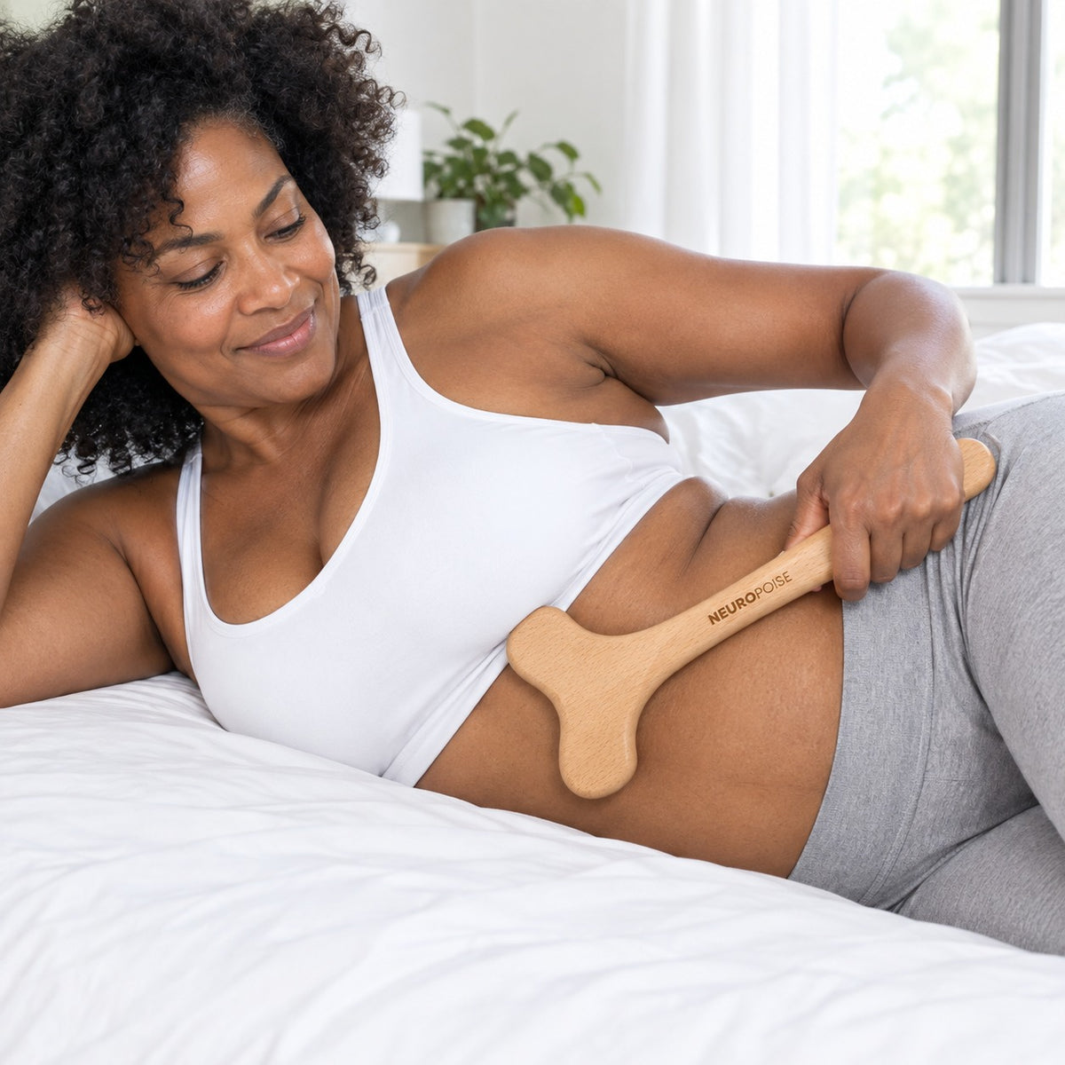 Woman gliding the Wood Therapy Body Massager along her waist