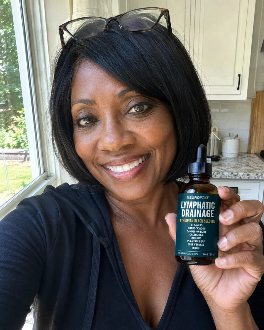 Keisha M. holding her Neuropoise Lymphatic Drainage Drops at home